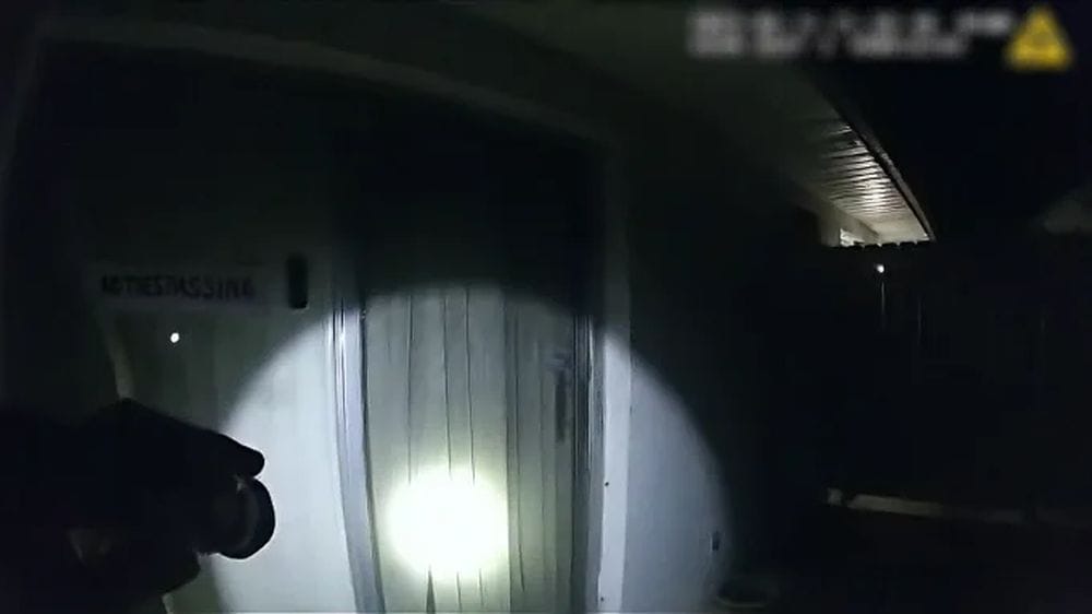 First person shot of police shining a torch at a suburan home looking for its inhabitant.